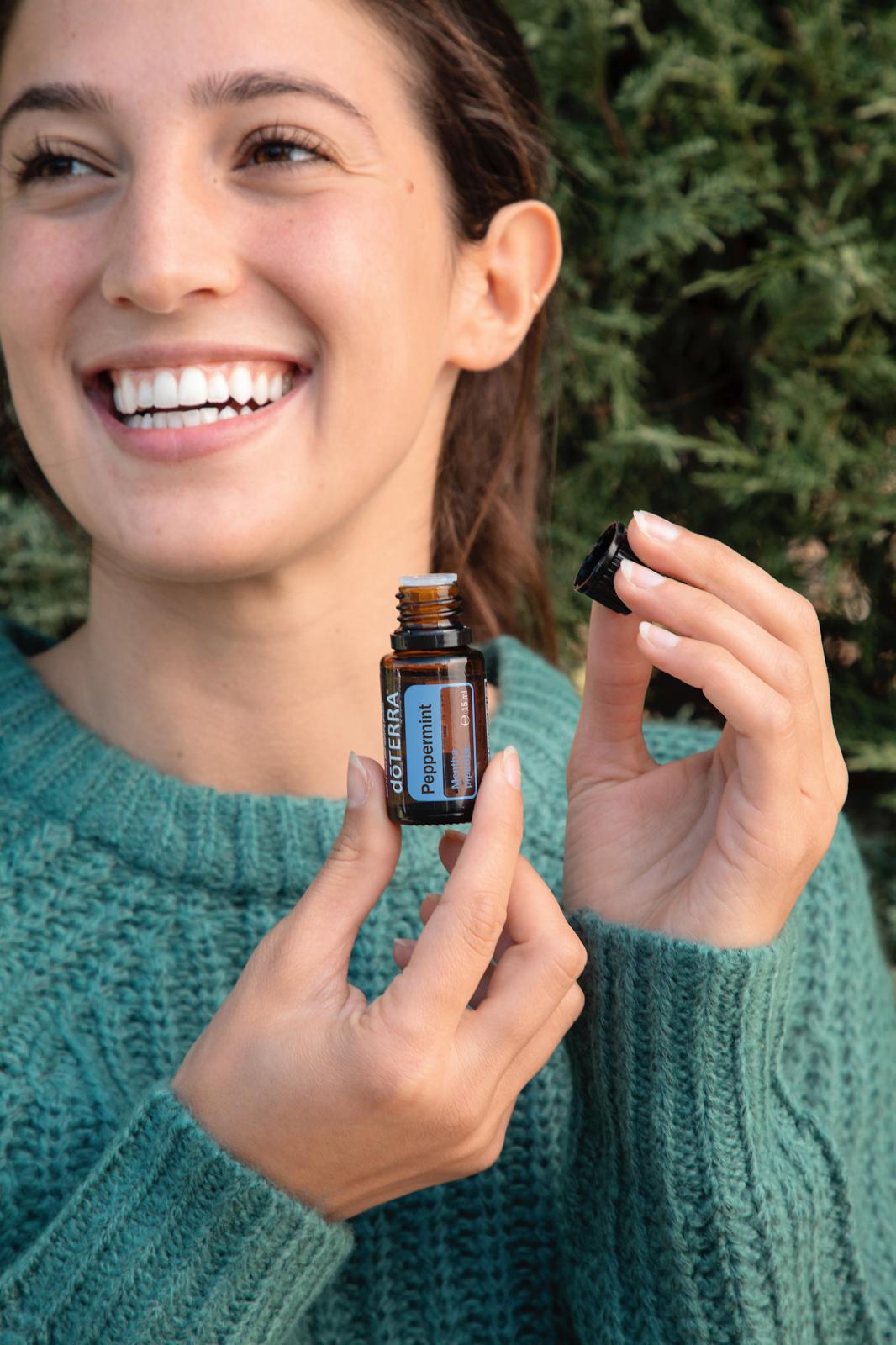 Frau hält dōTERRA Peppermint Kügelchen Flasche in der Hand